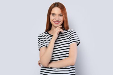 Açık gri arka planda güzel bir genç kadının portresi