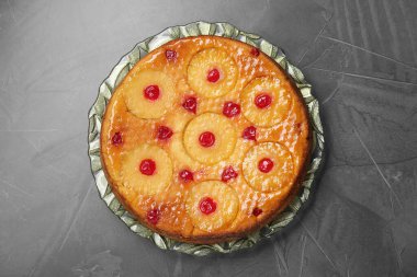 Gri desenli masa üzerinde lezzetli ananaslı kek tabağı, üst manzara.