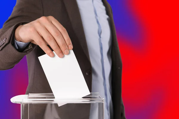 男子将选票放在彩色背景的投票箱里 特写镜头 — 图库照片