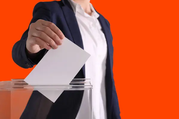 Woman Putting Her Vote Ballot Box Dark Orange Background Closeup — Stock Photo, Image