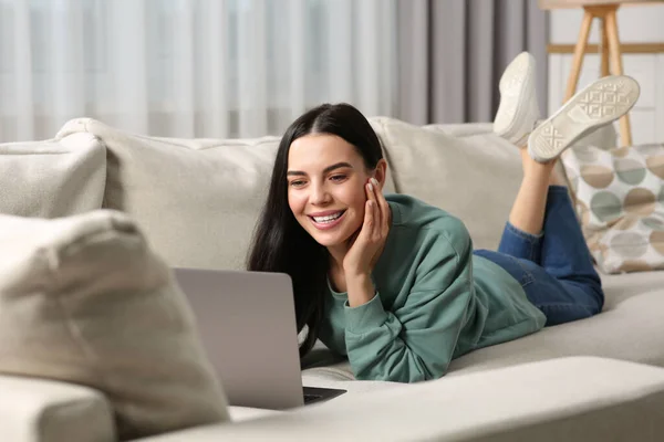 快乐的女人在家沙发上和笔记本电脑一起工作 — 图库照片