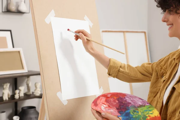 スタジオで紙でイーゼルに絵を描いた若い女性 クローズアップ — ストック写真
