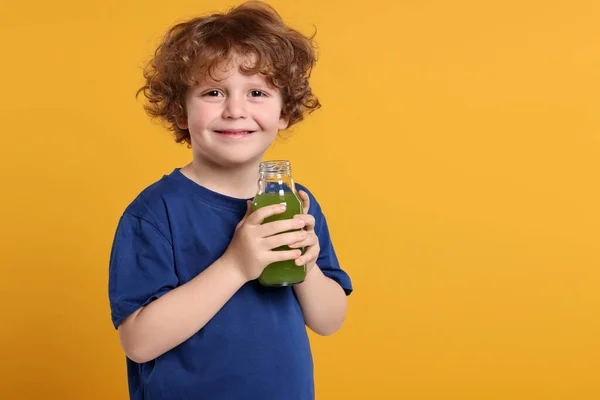 Söt Liten Pojke Med Glasflaska Färsk Juice Orange Bakgrund Utrymme — Stockfoto
