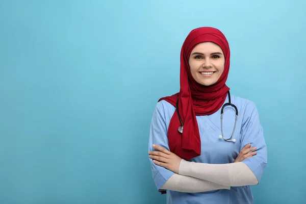 穆斯林妇女 头戴头巾 身穿医疗制服 带听诊器 浅蓝色背景 文字空间 — 图库照片
