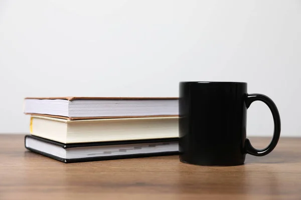 Black Ceramic Mug Stack Books Wooden Table — Stock Photo, Image