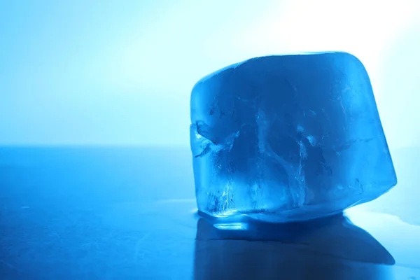 薄い青の背景 クローズアップ テキストのためのスペースに1つの透明な氷のキューブ カラートーン効果 — ストック写真
