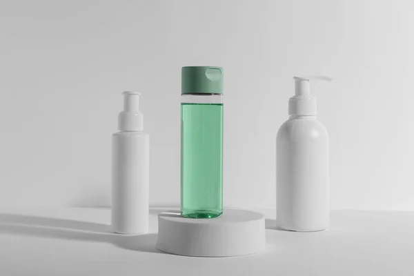 Bottiglie Con Diversi Prodotti Cosmetici Podio Sfondo Bianco — Foto Stock