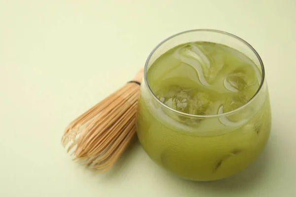 Szklanka Pysznej Mrożonej Herbaty Matcha Bambusowej Trzepaczki Zielonym Tle Zbliżenie — Zdjęcie stockowe