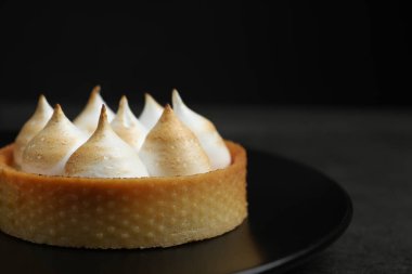 Siyah masada kremalı tart, yakın çekim ve metin için boşluk. Tatlı nefis.