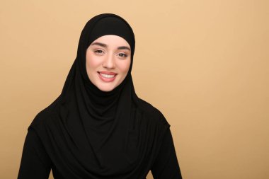 Bej arka planda tesettürlü Müslüman kadın portresi. Metin için boşluk