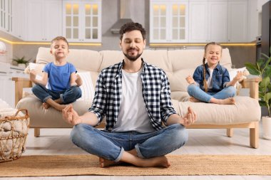 Çocuklu baba evde meditasyon yapıyor. Ahenk ve zen