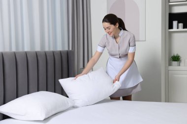 Genç hizmetçi otel odasında yatak yapma