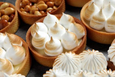 Koyu gri masada bir sürü turta var. Yakın plan. Lezzetli tatlı