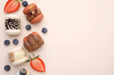 Lezzetli badem kurabiyeleri ve böğürtlenler bej masada, düz yerde. Metin için boşluk