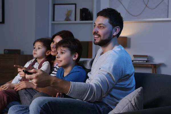 Szczęśliwa Rodzina Ogląda Telewizję Domu Wieczorem Ojciec Zmienia Kanały Pomocą — Zdjęcie stockowe