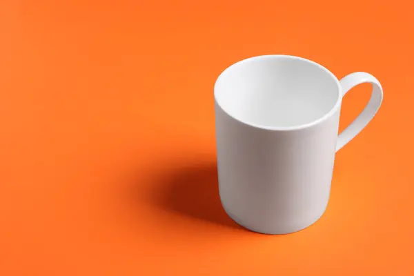 Jeden Biały Kubek Ceramiczny Pomarańczowym Tle Miejsce Tekst — Zdjęcie stockowe