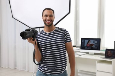 Modern fotoğraf stüdyosunda kamerası olan genç profesyonel fotoğrafçı.