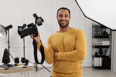 Modern fotoğraf stüdyosunda kamerası olan genç profesyonel fotoğrafçı.