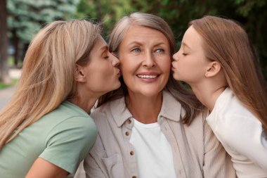 Three generations. Happy grandmother, her daughter and granddaughter outdoors