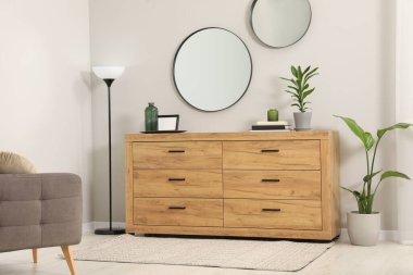 Çekmeceler, aynalar ve dekor elementlerinden oluşan rahat bir oda.