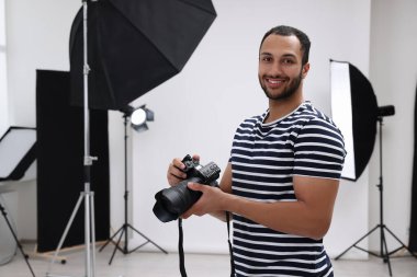 Modern fotoğraf stüdyosunda kamerası olan profesyonel bir fotoğrafçı.