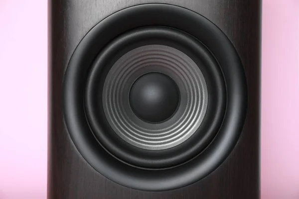 One wooden sound speaker on pink background, closeup