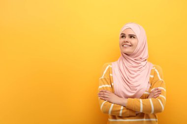 Turuncu arka planda tesettürlü Müslüman kadın portresi, metin için boşluk