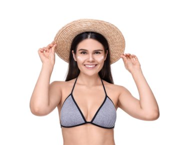 Yüzünde beyaz arka planda güneş kremi olan güzel genç bir kadın.