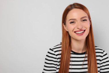 Açık gri arka planda güzel bir genç kadının portresi, metin için boşluk