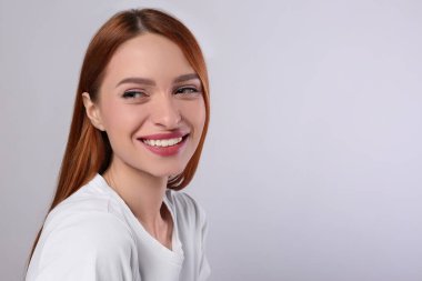 Açık gri arka planda güzel bir genç kadının portresi, metin için boşluk