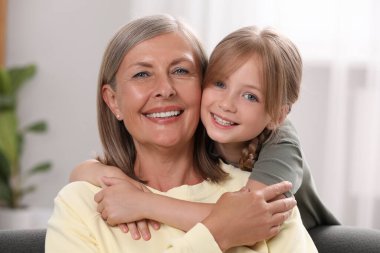 Mutlu büyükanne torununa evde sarılıyor.