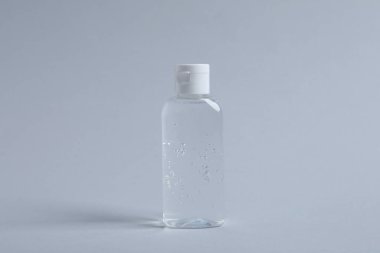 Açık gri arkaplanda bir şişe kozmetik ürünü