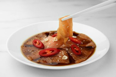 Beyaz mermer masadaki tabaktan lezzetli sashimi alıyorum, yakın plan.