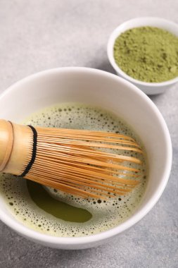 Bir fincan kibrit çayı ve bambu çırpısı açık gri masada, yukarıda.