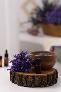 Bir şişe aromatik esanslı yağ ve içinde güzel çiçekler olan bir kütük.