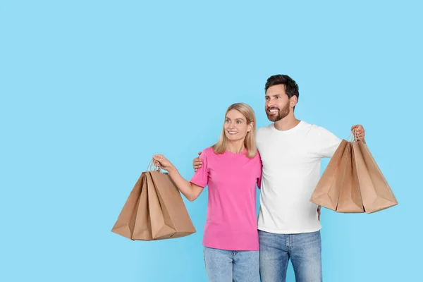 Familieneinkauf Glückliches Paar Mit Vielen Papiertüten Auf Hellblauem Hintergrund Raum — Stockfoto