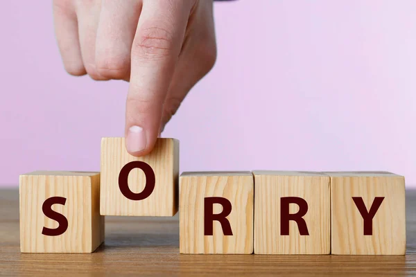 Man Putting Cube Letter Make Word Sorry Wooden Table Closeup — Stock fotografie