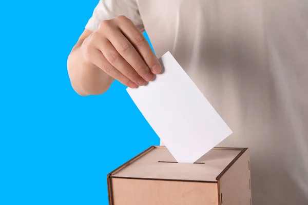 Mand Sætter Sin Stemme Stemmeurnerne Lyseblå Baggrund Closeup - Stock-foto