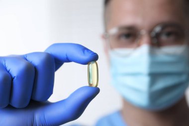 Doktor arka planda hap tutuyor, seçici odaklanma. Metin için boşluk