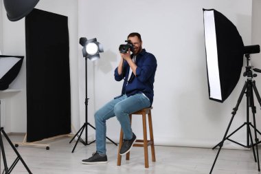 Modern fotoğraf stüdyosunda fotoğraf çeken genç profesyonel fotoğrafçı.
