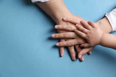Aile açık mavi arka planda el ele tutuşuyor. Metin için boşluk