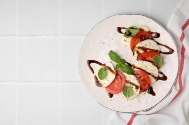 Beyaz fayanslı masa üzerinde balzamik sirkeyle nefis Caprese salatası. Metin için boşluk