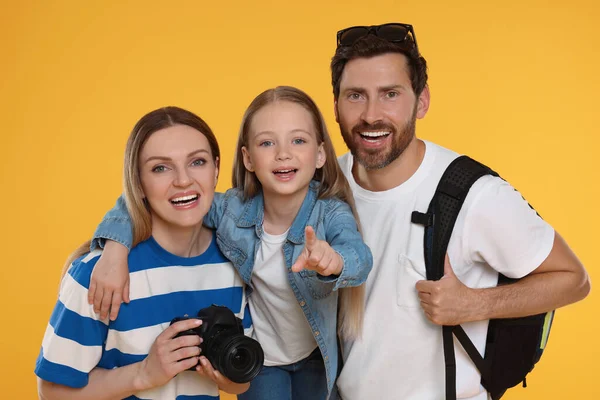 Happy family with camera on orange background