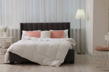 Şık bir yatak odası, rahat bir yatak odası, komodin ve lamba.