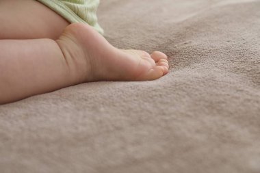 Bebek evde yatakta oturuyor, yakın plan. Metin için boşluk