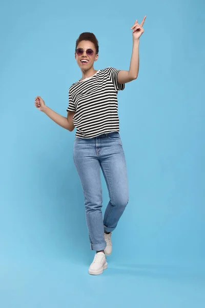 Glad Ung Kvinna Solglasögon Dansar Ljusblå Bakgrund — Stockfoto