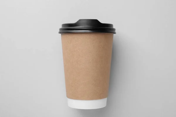 One paper cup on light grey background, top view. Coffee to go