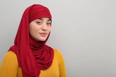 Açık gri arkaplanda tesettürlü Müslüman kadın portresi, metin için boşluk