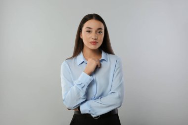 Açık gri arka planda güzel bir genç kadının portresi