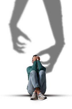 Suffering from hallucinations. Scared man closing eyes because of shadow of monster hands reaching to him clipart